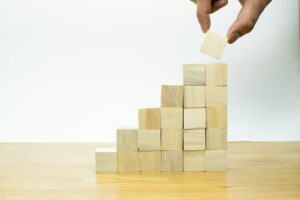 Final piece of the puzzle being added to stacked blocks, representing how a CFO brings structure and strategic guidance to help a business thrive.