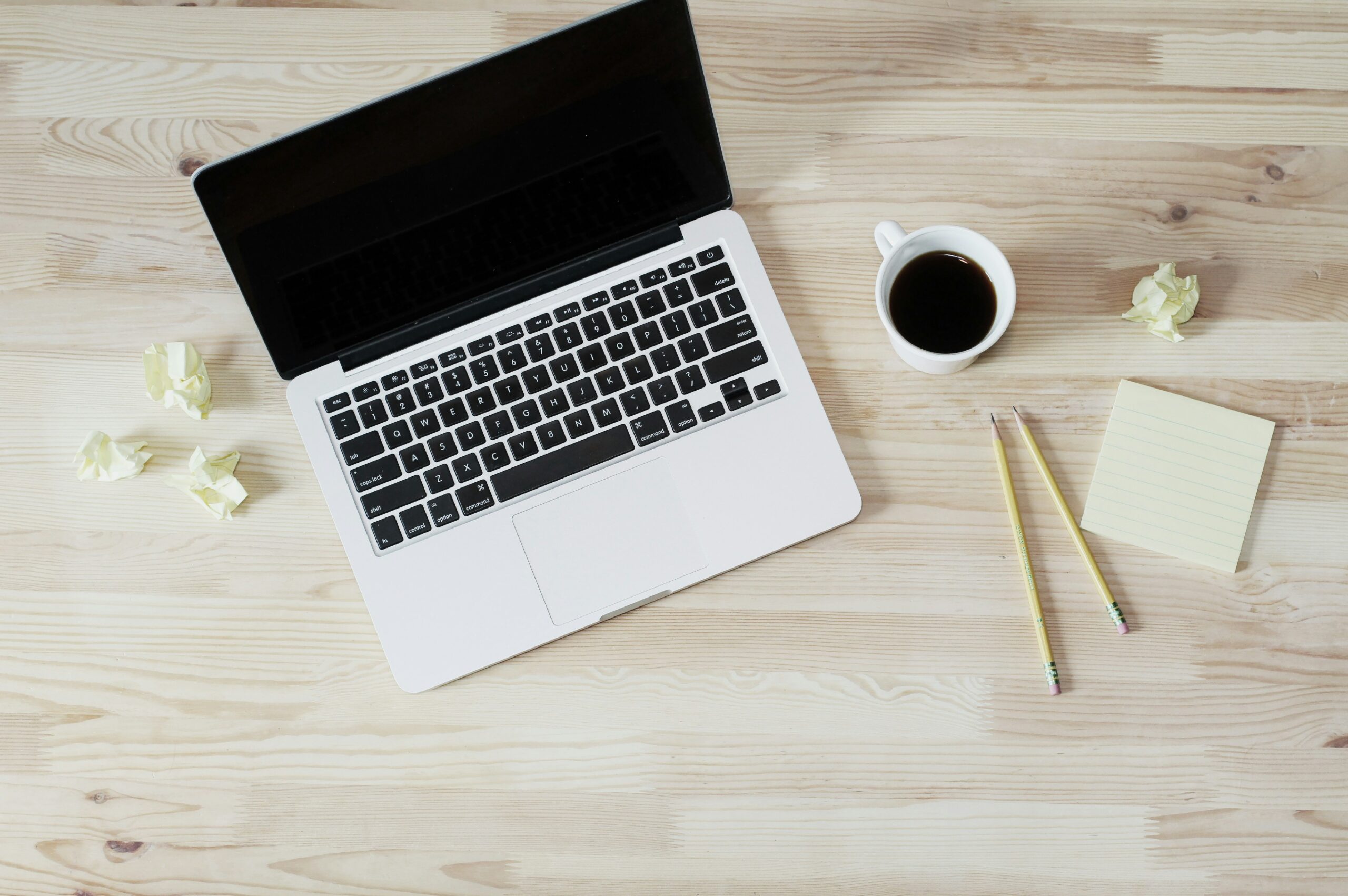 Laptop on a clean desk with coffee and notes, representing day to day financial planning and decision making by a fractional CFO